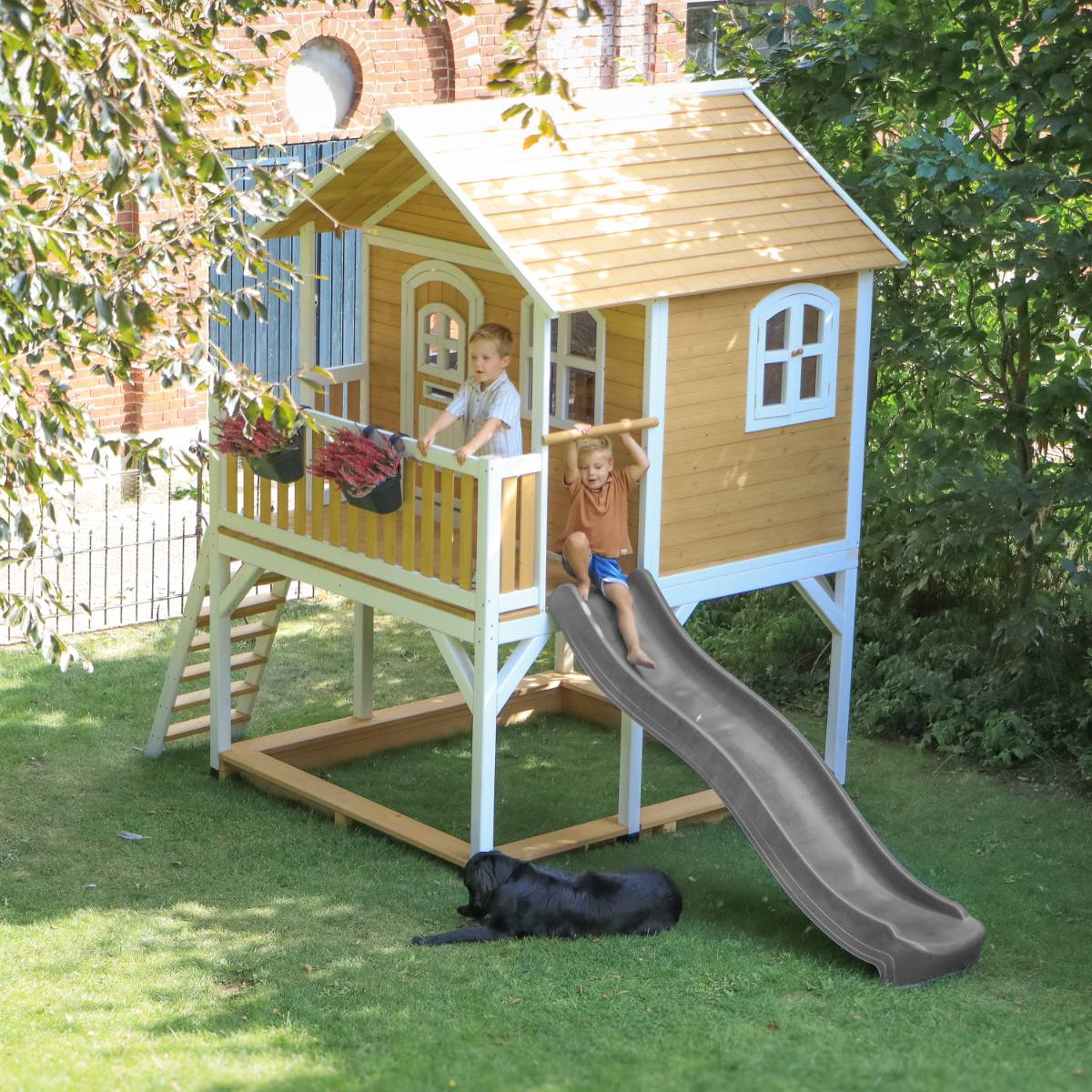 Children playing in a Pragma wooden playhouse